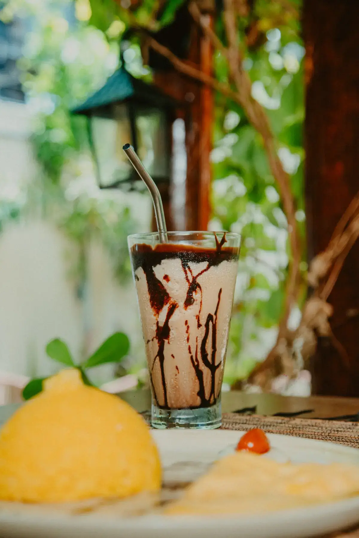 Bebida gelada de chocolate com calda escorrendo no copo
