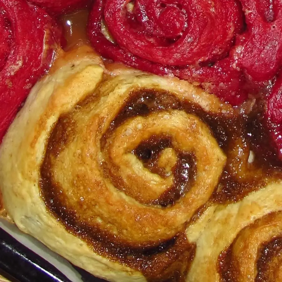 Cinnamon roll em espiral entre rolls red velvet, na bandeja da Roll