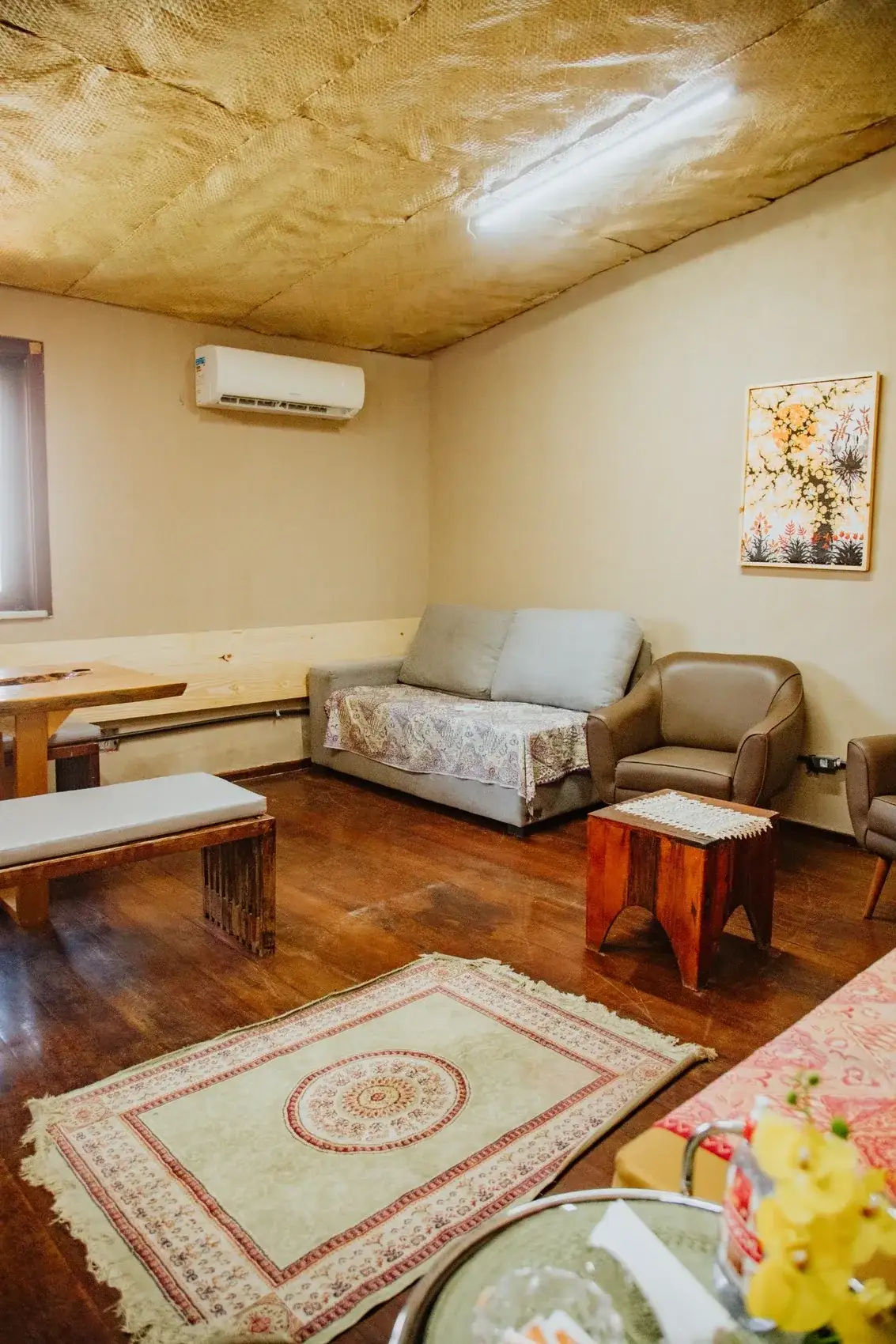 Sala privativa no andar de cima, com sofá, poltronas, mesa de centro e tapete
